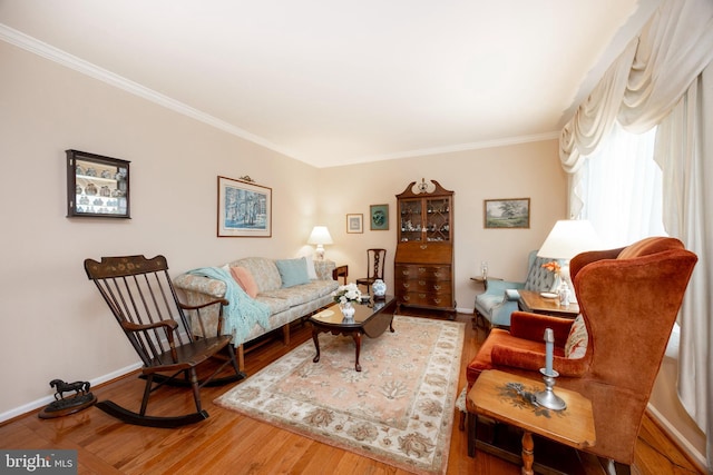 living area featuring crown molding, wood finished floors, and baseboards