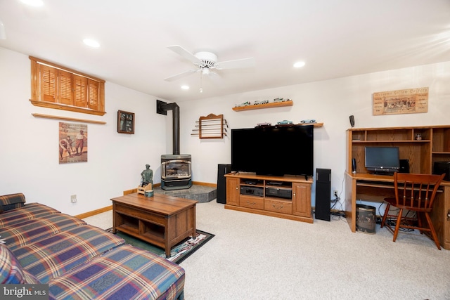 living room with baseboards, a wood stove, recessed lighting, ceiling fan, and light colored carpet