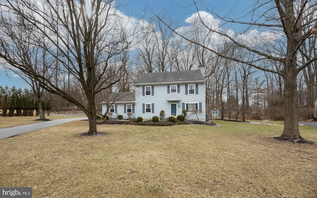 colonial inspired home featuring a front lawn