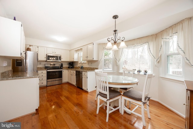 kitchen with light wood finished floors, appliances with stainless steel finishes, and a sink