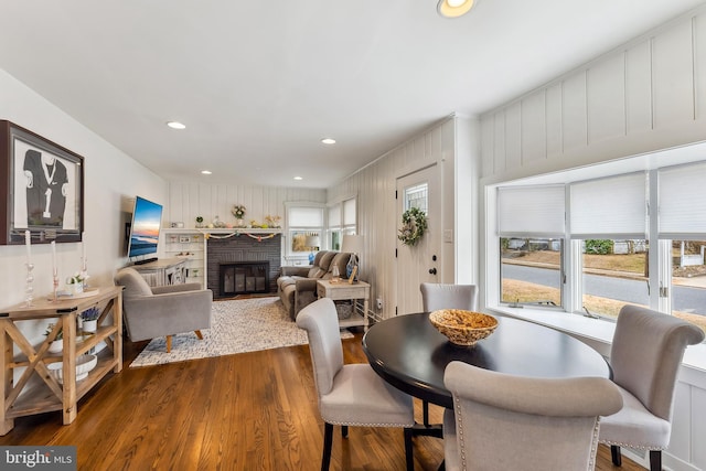 dining area with dark wood-style floors, recessed lighting, and a fireplace