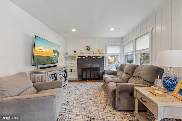 living room with a brick fireplace, light wood finished floors, and recessed lighting