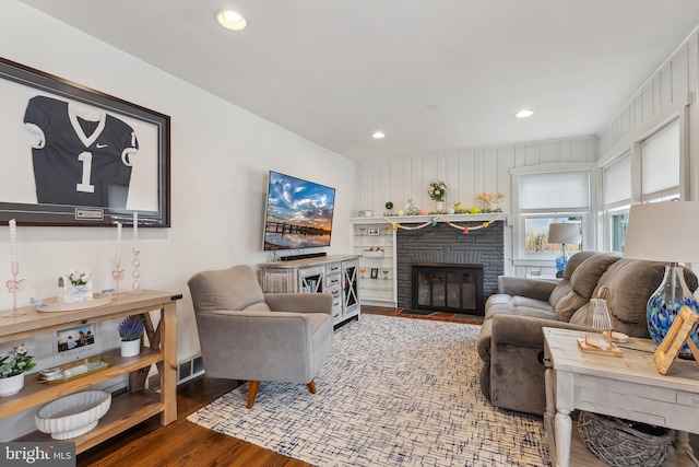 living area with a fireplace, wood finished floors, and recessed lighting