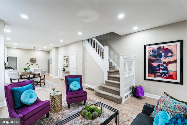 living room with recessed lighting, stairway, baseboards, and wood finished floors