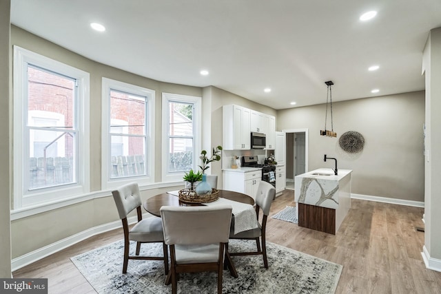 dining area with light wood-style floors, baseboards, and recessed lighting