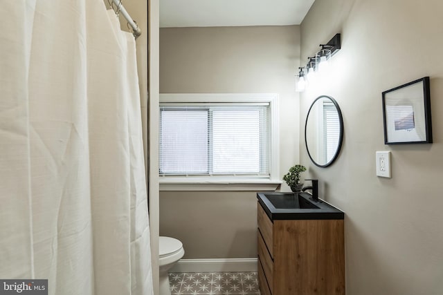 bathroom with vanity, toilet, and baseboards