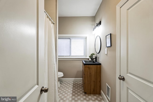 bathroom featuring visible vents, toilet, vanity, baseboards, and tile patterned floors