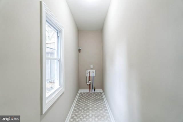 hall with baseboards and tile patterned floors