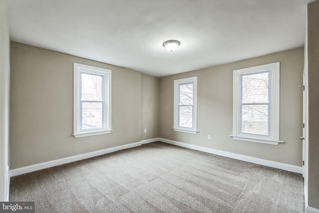 carpeted spare room featuring baseboards