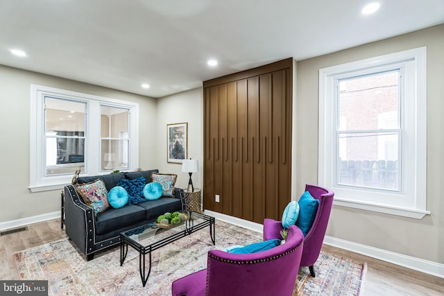 living area with visible vents, baseboards, and wood finished floors