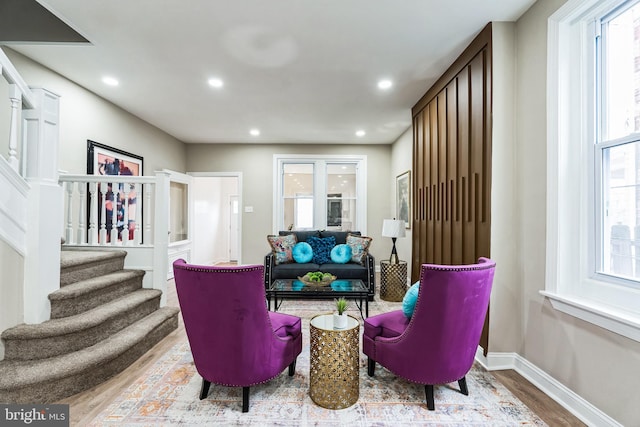 sitting room featuring stairs, baseboards, wood finished floors, and recessed lighting