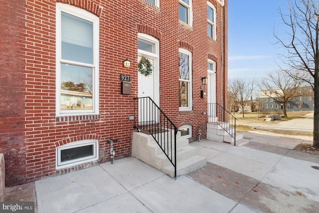 doorway to property featuring brick siding