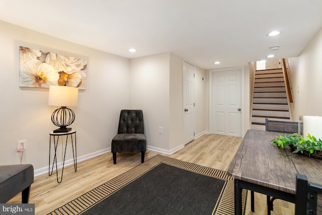 sitting room with stairway, recessed lighting, baseboards, and wood finished floors