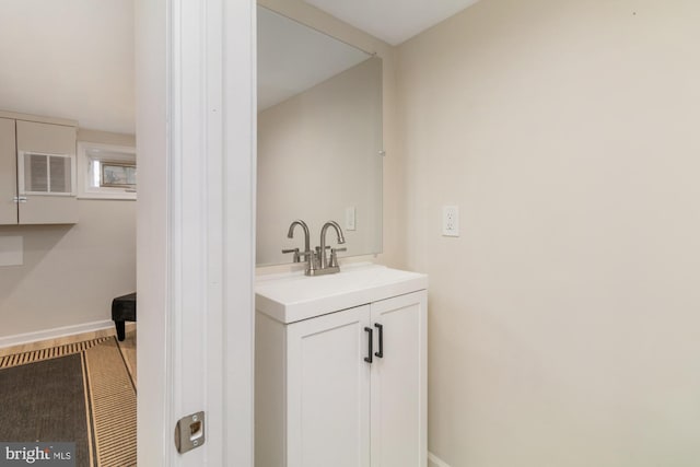 bathroom featuring visible vents, baseboards, and vanity