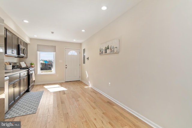 kitchen featuring light wood-style flooring, recessed lighting, appliances with stainless steel finishes, light countertops, and baseboards