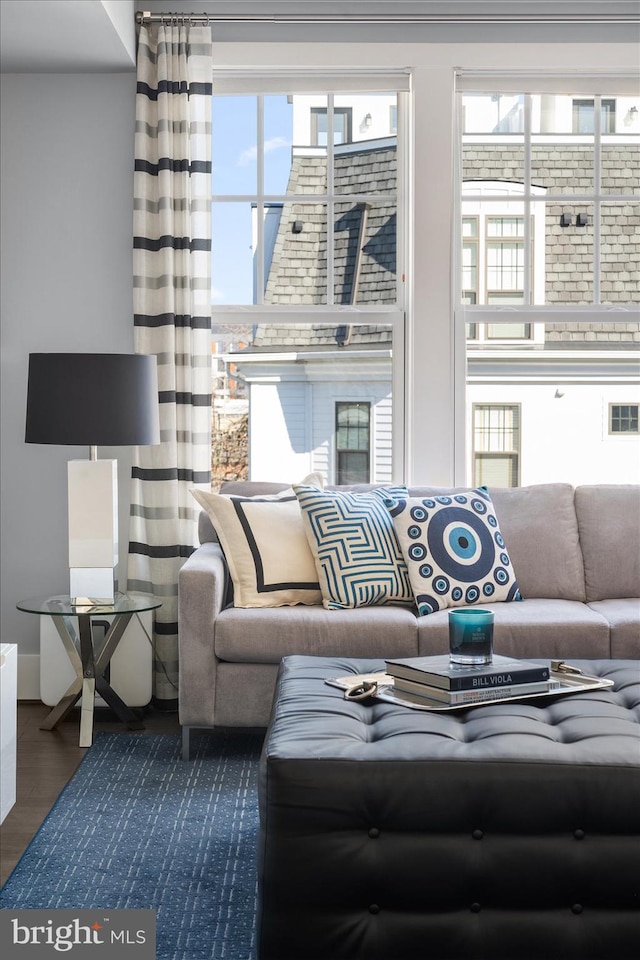 living room featuring dark wood-style flooring, a healthy amount of sunlight, and visible vents