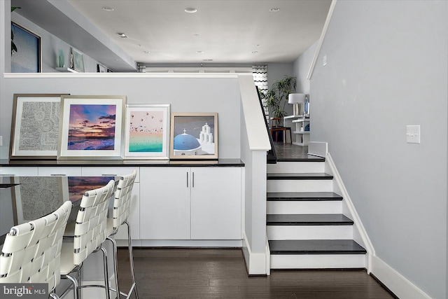 staircase featuring baseboards and wood finished floors