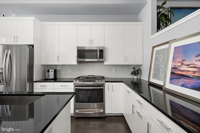 kitchen with appliances with stainless steel finishes, dark countertops, backsplash, and white cabinets