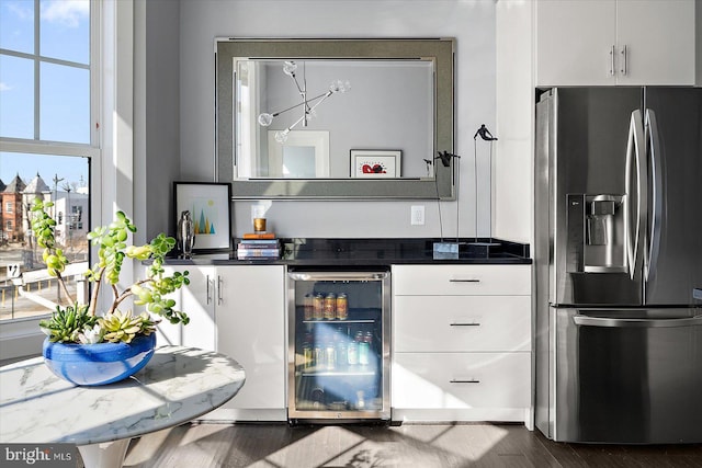 kitchen with dark wood-style floors, dark countertops, white cabinetry, beverage cooler, and stainless steel fridge with ice dispenser