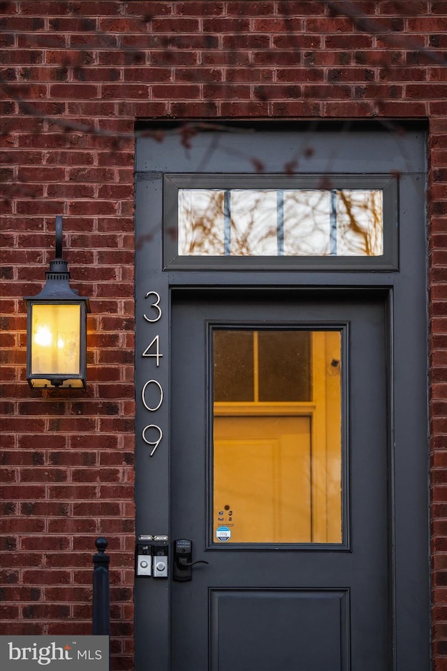 view of exterior entry featuring brick siding