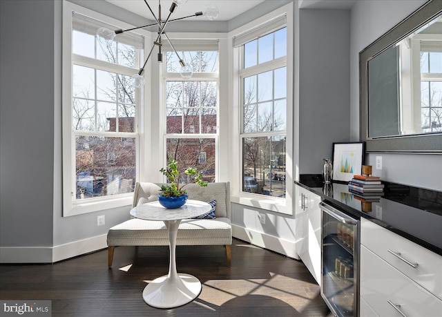 dining area featuring dark wood-type flooring, beverage cooler, plenty of natural light, and baseboards