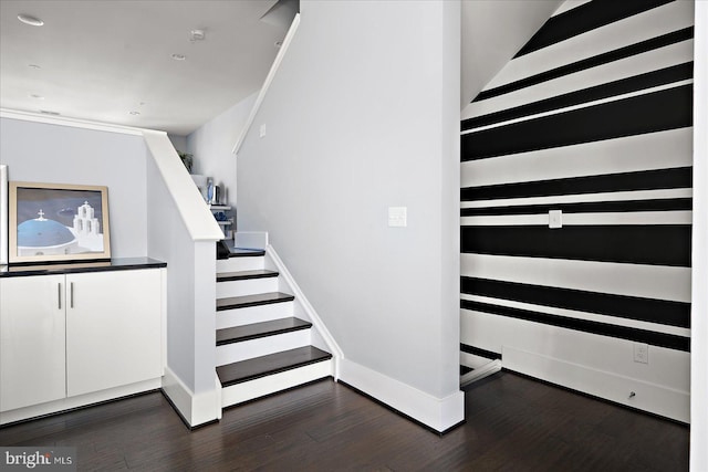 staircase featuring baseboards and wood finished floors