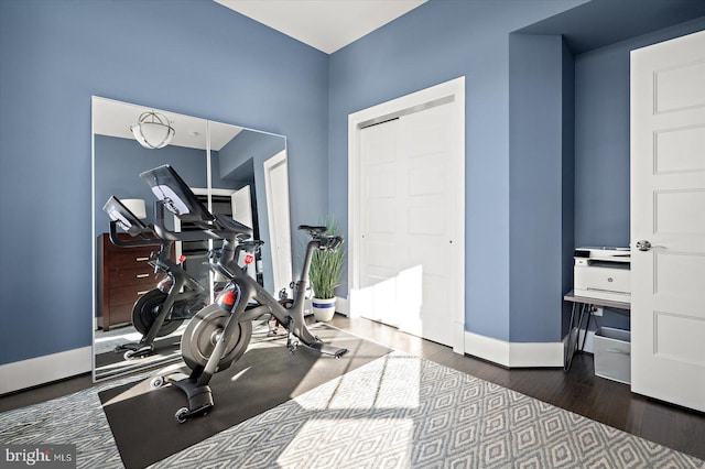 exercise room featuring wood finished floors and baseboards