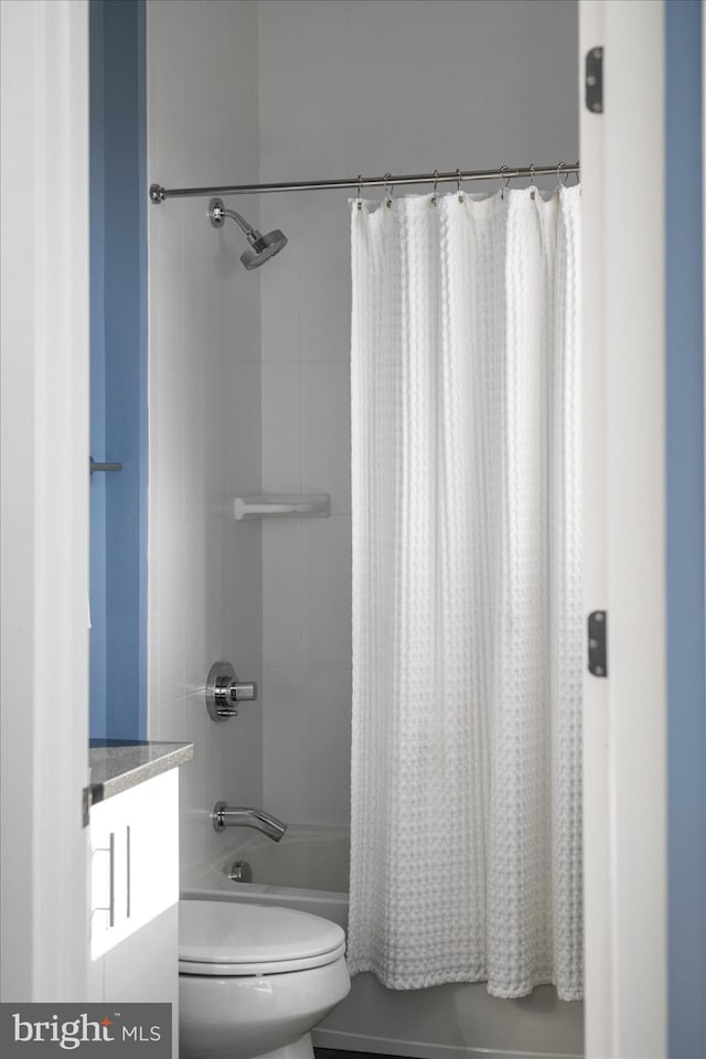 bathroom with shower / bath combo, vanity, and toilet