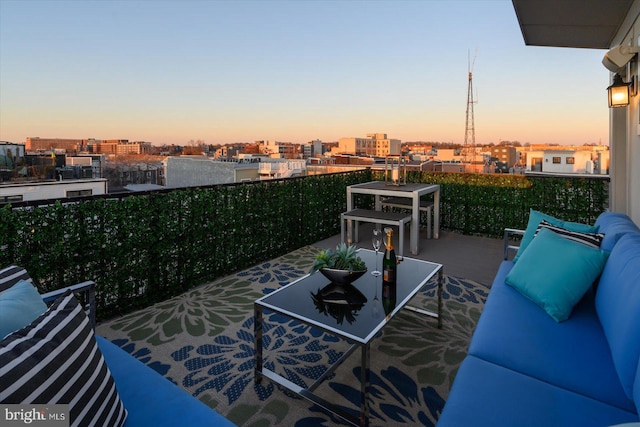 balcony at dusk with a view of city and an outdoor living space