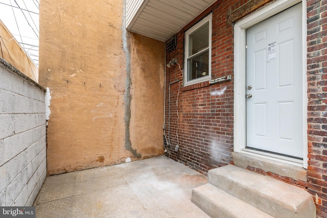 entrance to property featuring brick siding