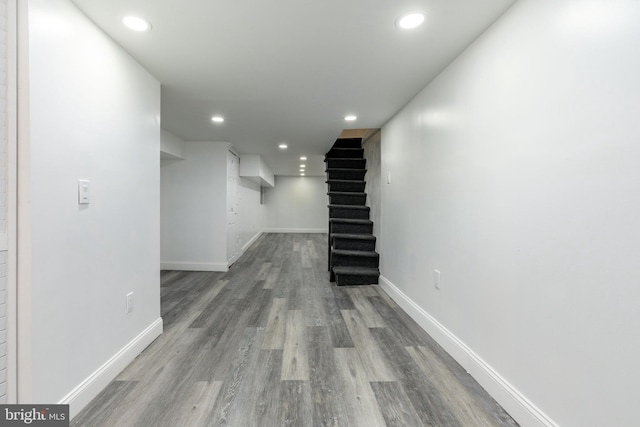 basement featuring stairway, recessed lighting, baseboards, and wood finished floors