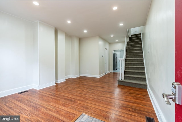 unfurnished living room with stairs, recessed lighting, wood finished floors, and visible vents