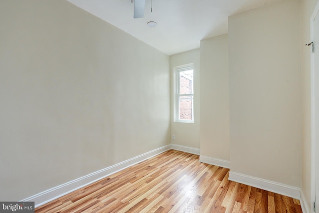 empty room featuring a ceiling fan, light wood-type flooring, and baseboards