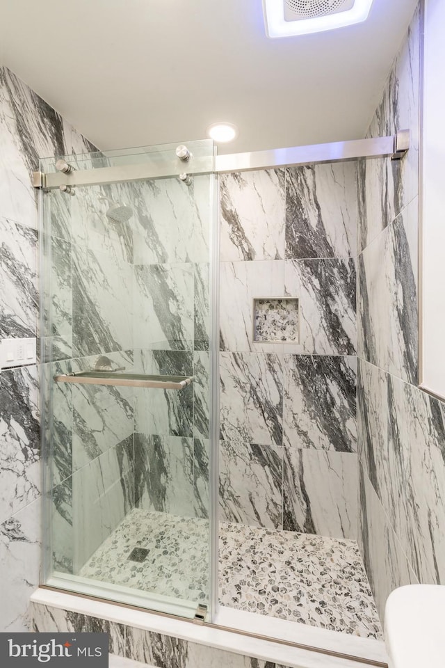 full bathroom featuring toilet, visible vents, and a marble finish shower