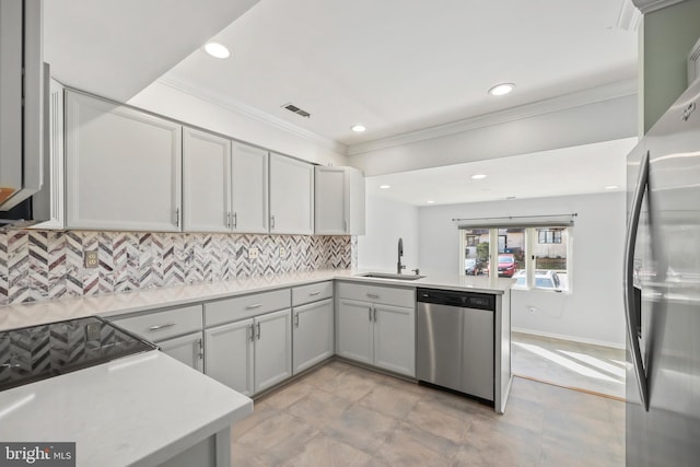 kitchen with ornamental molding, decorative backsplash, light countertops, a sink, and appliances with stainless steel finishes