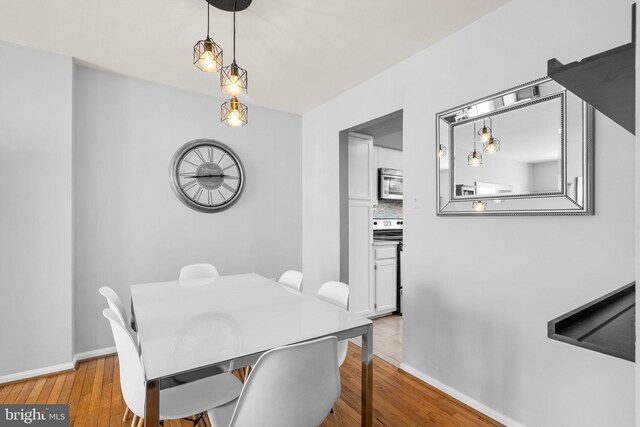 dining space with light wood-style flooring and baseboards