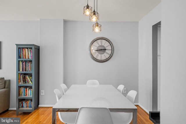 dining space featuring light wood-style floors and baseboards