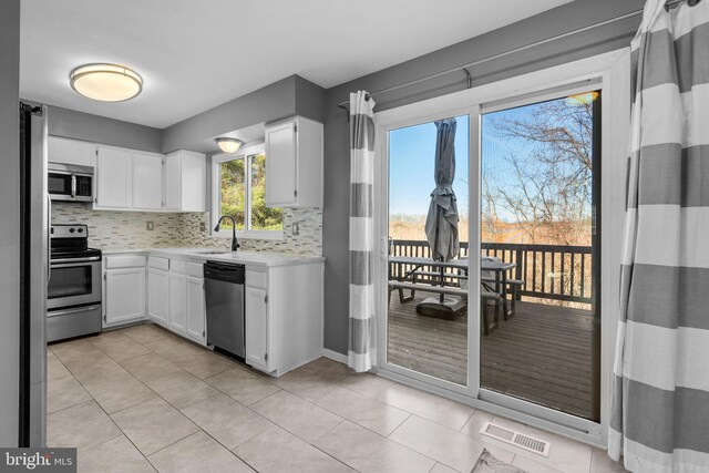 kitchen with visible vents, a sink, light countertops, appliances with stainless steel finishes, and backsplash