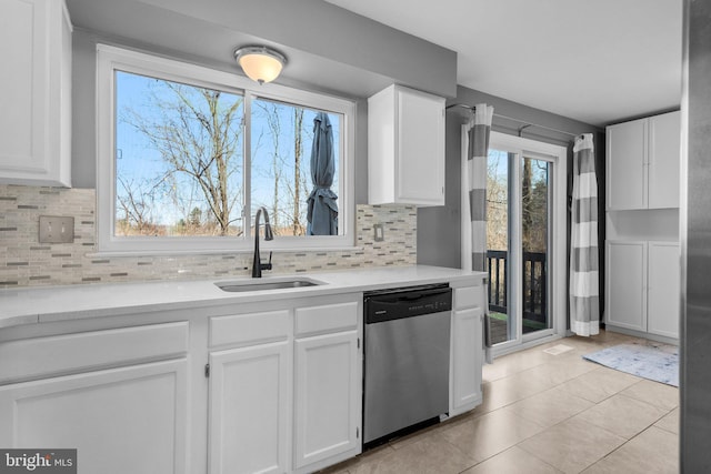 kitchen featuring a sink, dishwasher, white cabinets, and light countertops