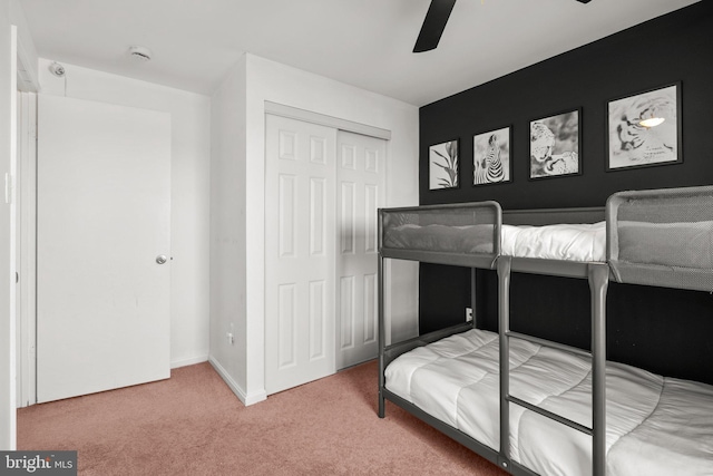 bedroom featuring a ceiling fan, carpet, a closet, and baseboards