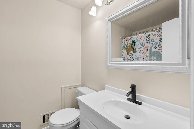 bathroom with vanity, toilet, and visible vents