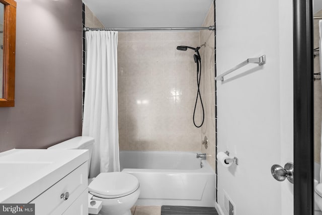 bathroom featuring visible vents, toilet, vanity, and shower / bath combination with curtain