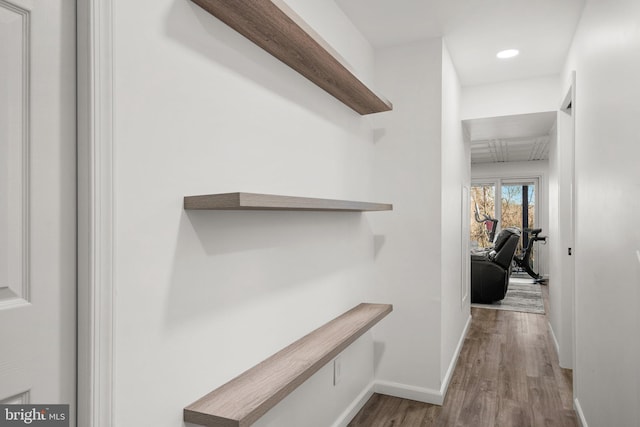 hall featuring recessed lighting, wood finished floors, and baseboards