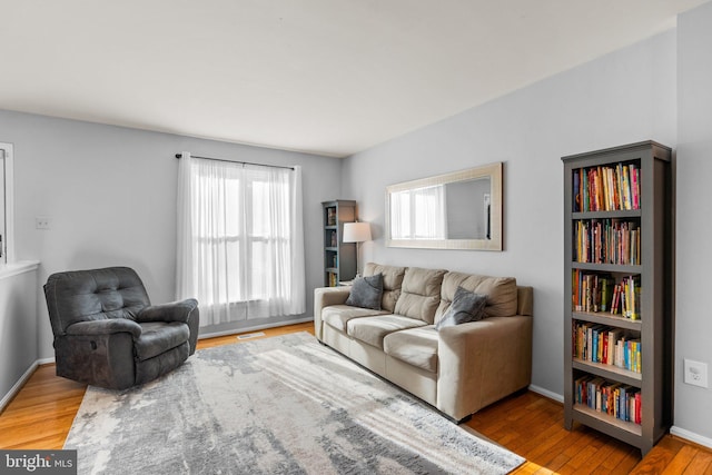 living area with visible vents, baseboards, and wood finished floors