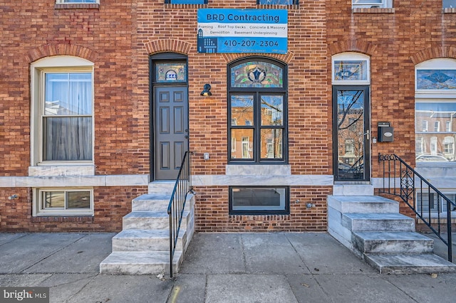 view of exterior entry featuring brick siding