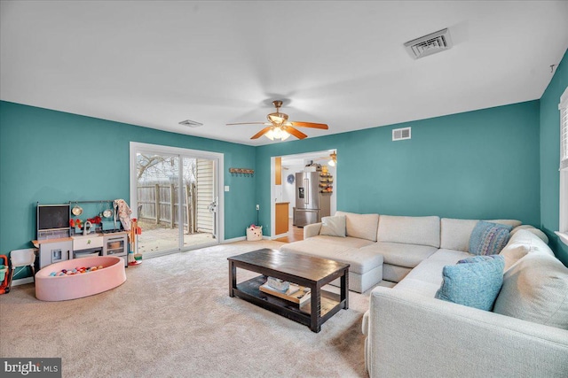 carpeted living area with a ceiling fan, visible vents, and baseboards