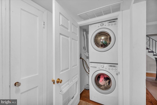 laundry room featuring stacked washer and dryer, laundry area, and visible vents