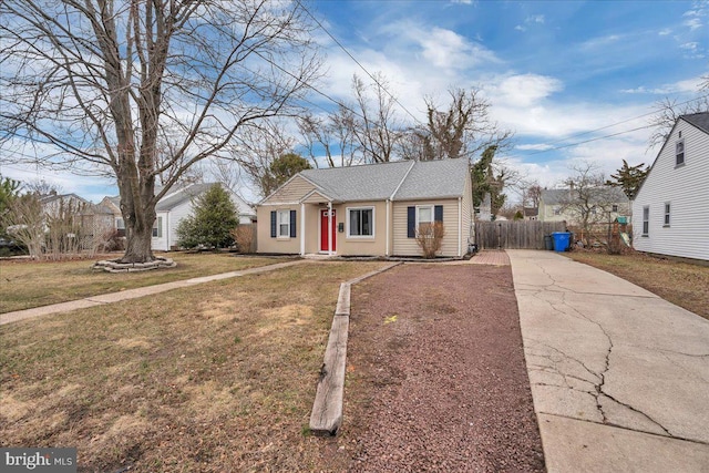 view of front of house with concrete driveway, a front lawn, and fence