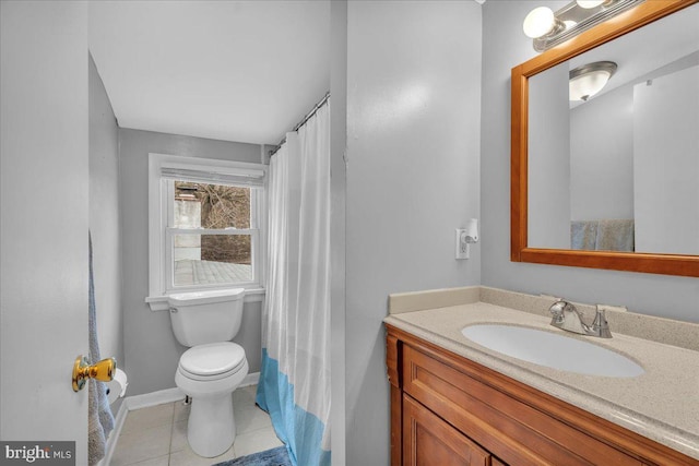 bathroom featuring baseboards, vanity, toilet, and tile patterned floors