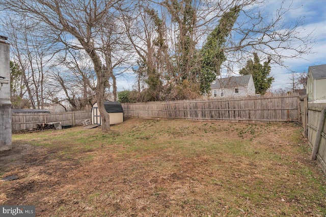 view of yard with a storage shed, a fenced backyard, and an outdoor structure